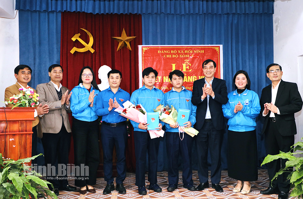 Lãnh đạo Tỉnh đoàn và chính quyền xã Hồi Ninh (Kim Sơn) tặng hoa chúc mừng anh em song sinh Nguyễn Duy Quang và Nguyễn Thành Vinh được kết nạp vào Đảng trước khi lên đường nhập ngũ. Ảnh: Đức Lam