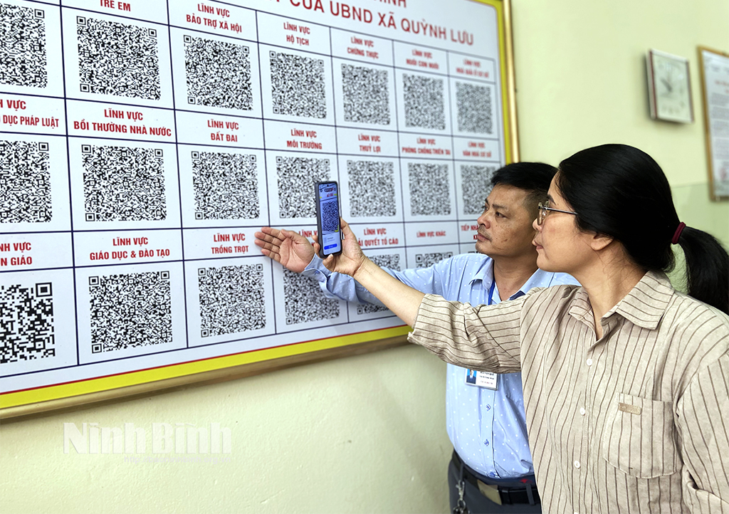 Công chức Bộ phận Tiếp nhận và Trả kết quả xã Quỳnh Lưu (Nho Quan) hướng dẫn công dân quét mã QR tra cứu TTHC.