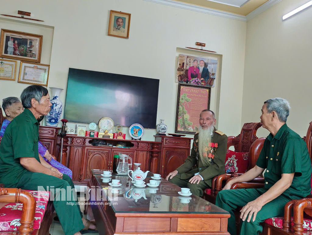 Cựu chiến binh Đinh Đức Dư (người thứ hai từ bên phải qua) chia sẻ với các cựu chiến binh thôn Hoàng Sơn Tây về ký ức trận đánh cứ điểm Him Lam trong Chiến dịch Điên Biên Phủ.