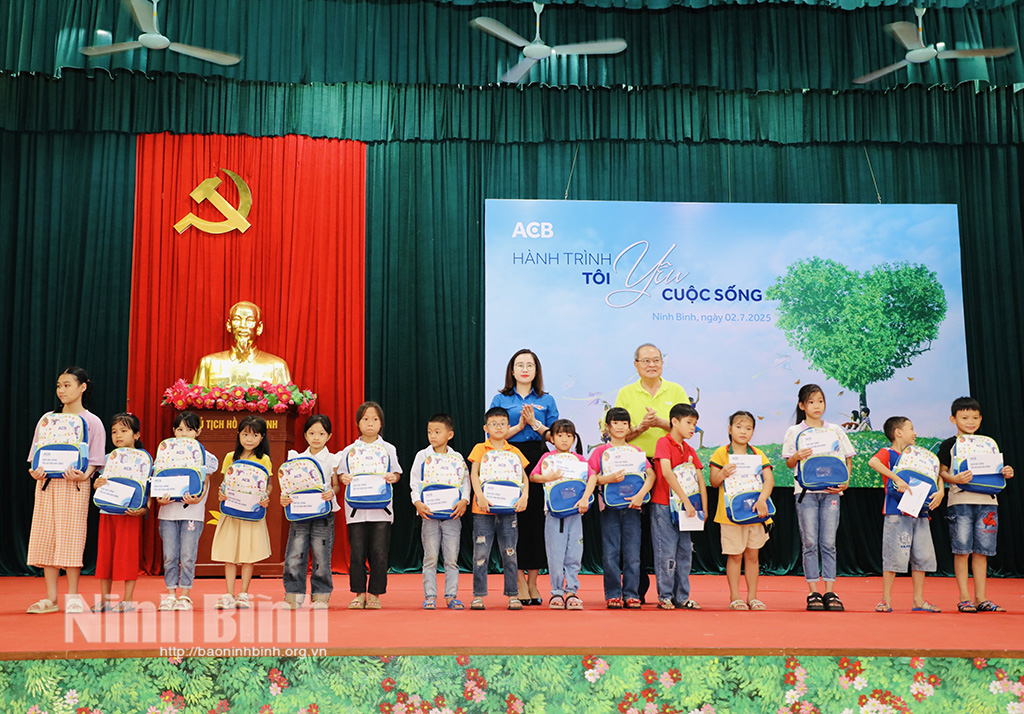 Đại diện lãnh đạo Tỉnh đoàn và nhà tài trợ trao quà cho các em học sinh.