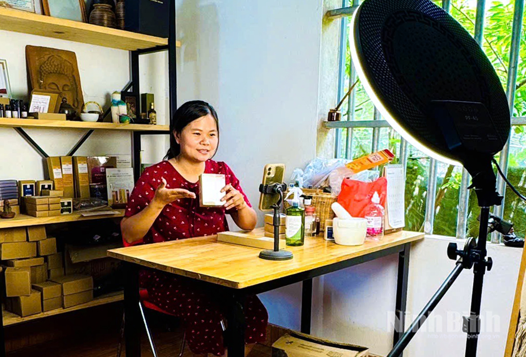 Chị Nguyễn Thị Thu Hoài quay video quảng cáo sản phẩm Hương hồng hạc đạt OCOP 4 sao trên sàn thương mại điện tử. Ảnh: Lan Anh