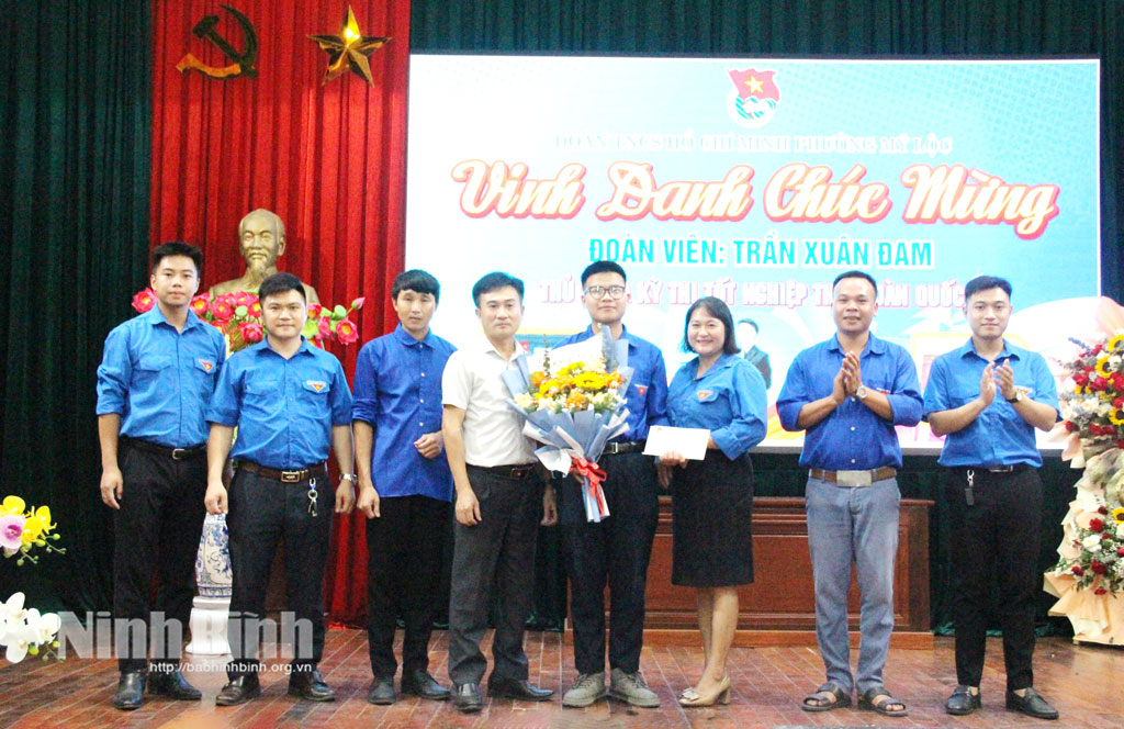 Lãnh đạo Ủy ban MTTQ Việt Nam và Đoàn TNCS Hồ Chí Minh phường Mỹ Lộc tặng hoa chúc mừng tân thủ khoa Trần Xuân Đam.