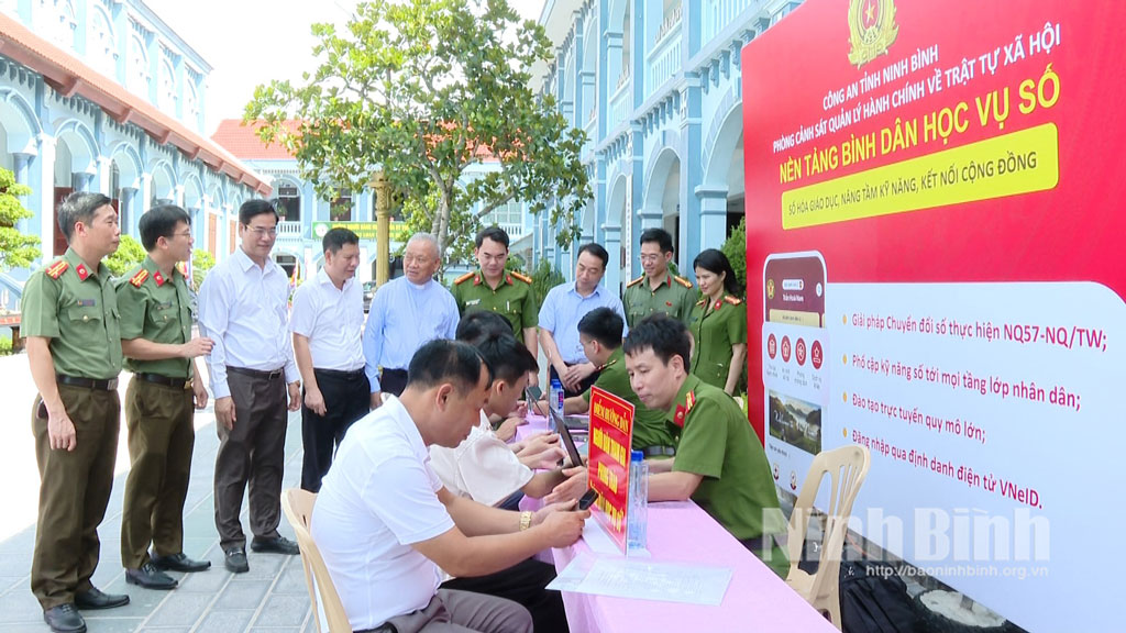 Các đại biểu tham quan điểm hướng dẫn người dân kích hoạt, đăng nhập, sử dụng VNeID và tham gia phong trào “Bình dân học vụ số”.