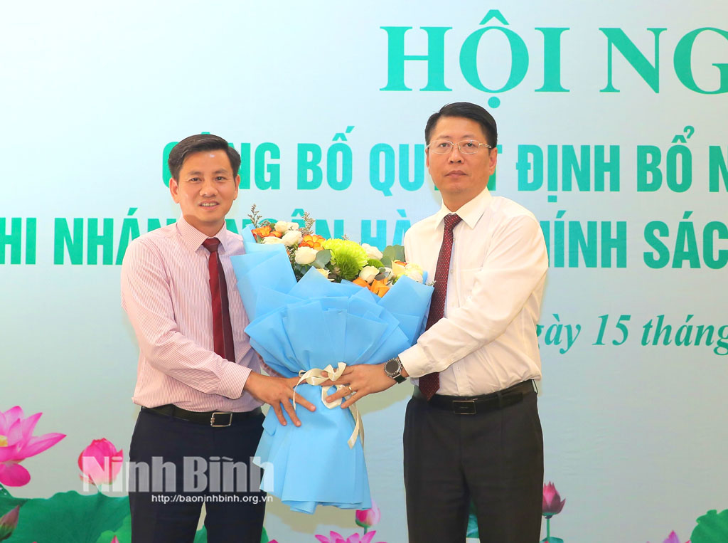 Đồng chí Trần Song Tùng, Ủy viên Ban Thường vụ Tỉnh ủy, Phó Chủ tịch UBND tỉnh, tặng hoa chúc mừng đồng chí Giám đốc Ngân hàng Chính sách xã hội tỉnh.