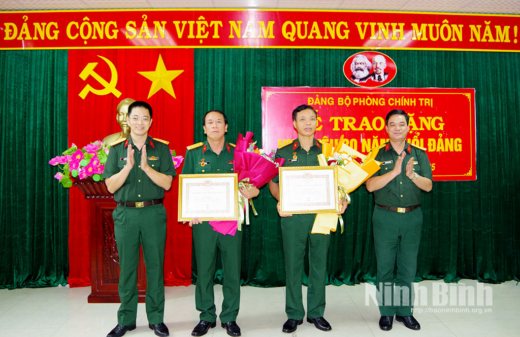 Các đồng chí trong Đảng ủy Phòng Chính trị trao Huy hiệu 30 năm tuổi Đảng cho các đồng chí đảng viên.