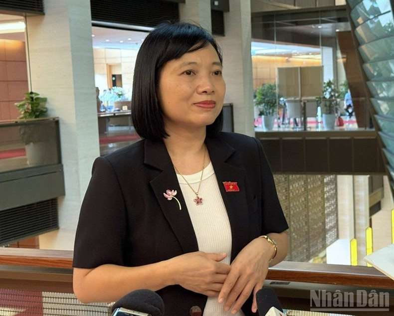 Deputy Nguyen Thi Viet Nga shares with reporters in the hallway of the NA House. (Photo: TRUNG HUNG)