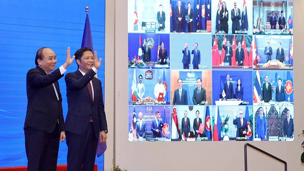 Vietnamese Prime Minister Nguyen Xuan Phuc (L) and Minister of Industry and Trade Tran Tuan Anh, together with leaders of other RCEP member countries, witness the pact signing via videoconference on November 15, 2020.