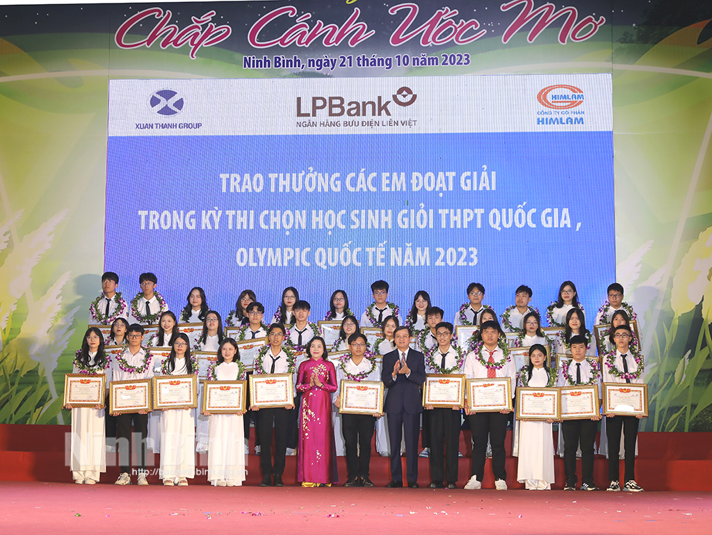 Deputy Head of the PCC's Commission for Organisation Nguyen Thi Thanh and Secretary of Ninh Binh party committee Doan Minh Huan present rewards to students.