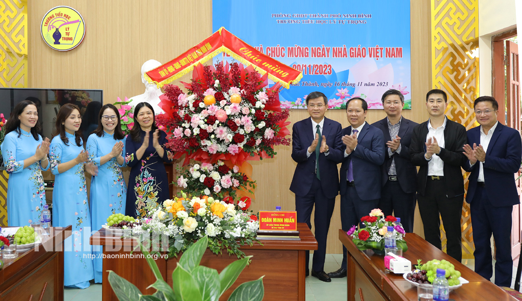 Secretary of the provincial Party committee Doan Minh Huan congratulates leaders and staff members of the Ly Tu Trong Primary school in Ninh Binh city.