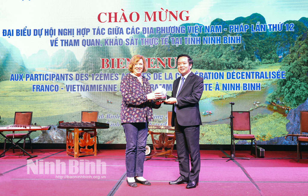 Chairman of the provincial People's Committee Pham Quan Ngoc presents gifts to Ms Catherine Deroche.