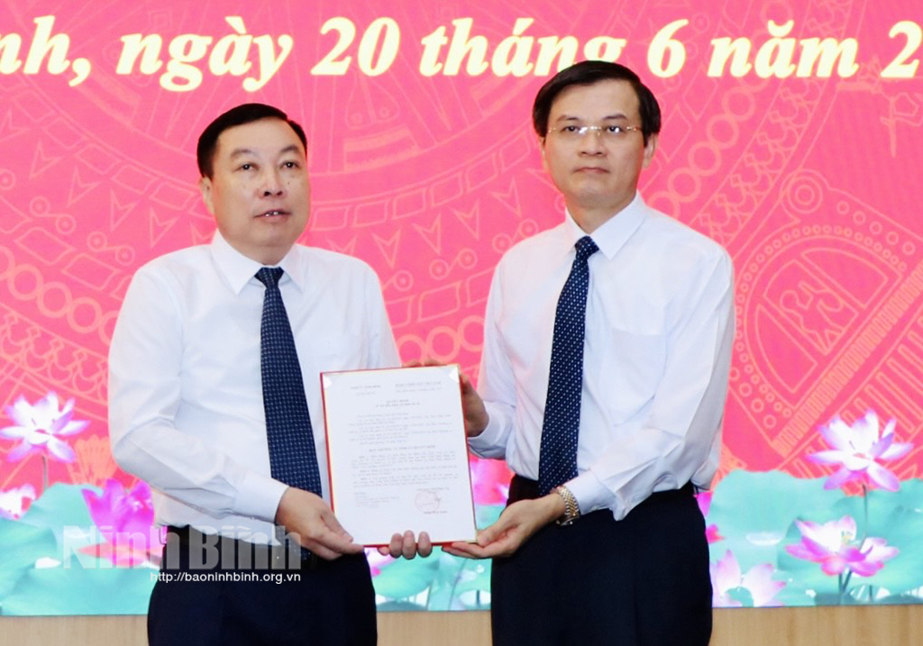 Secretary of Ninh Binh provincial party organisation Doan Minh Huan hands over Decision to Dinh Van Tien.